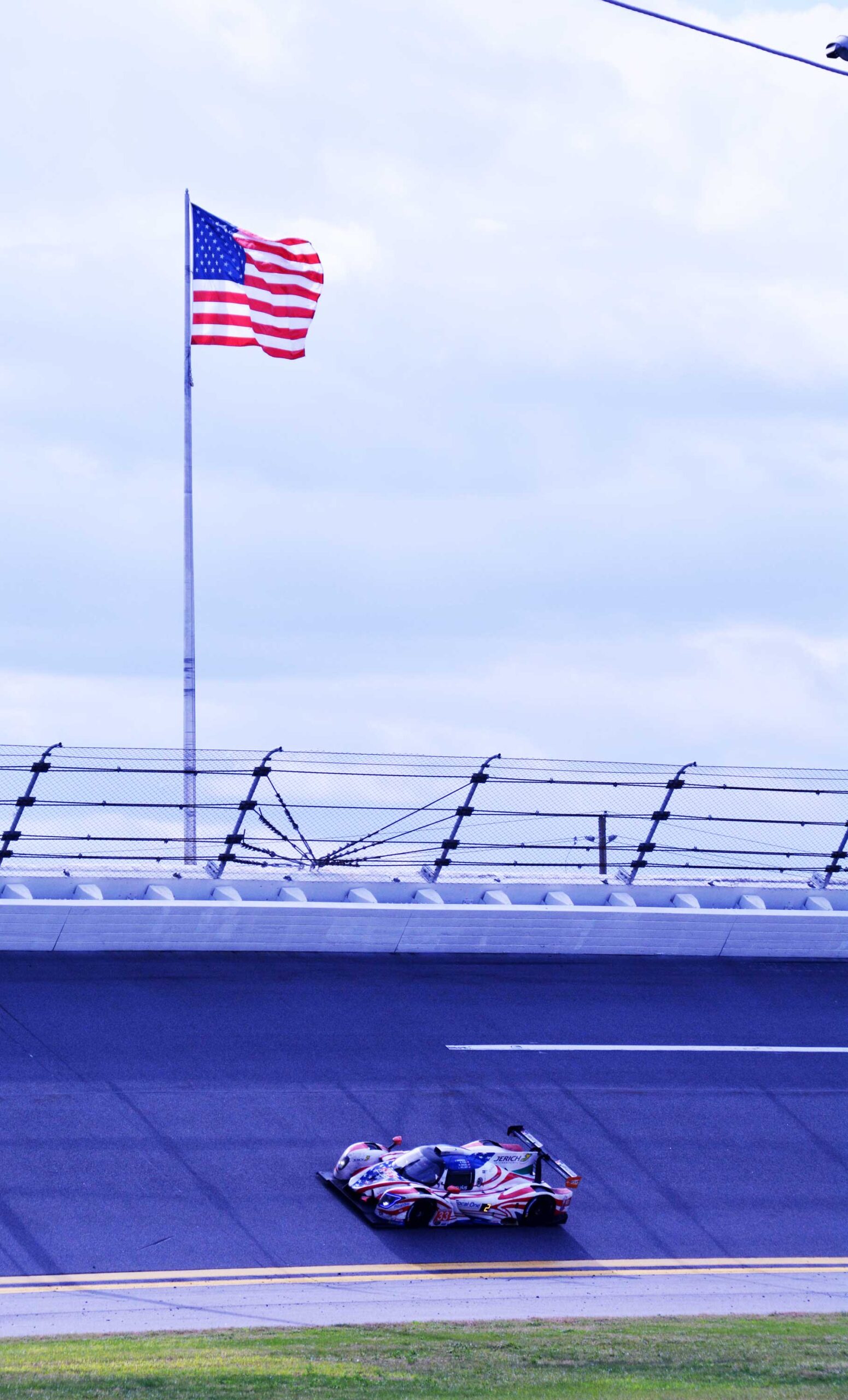American flag and car on track
